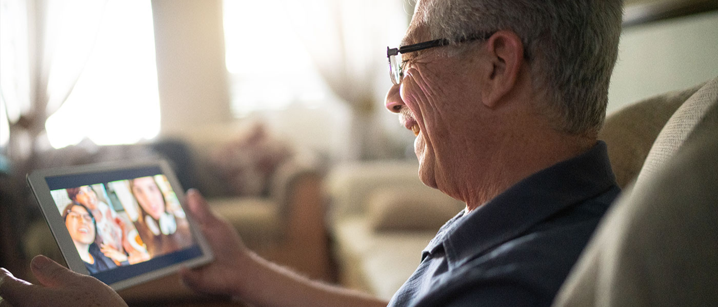 Senior Man Uses App on Phone to Speak with Family