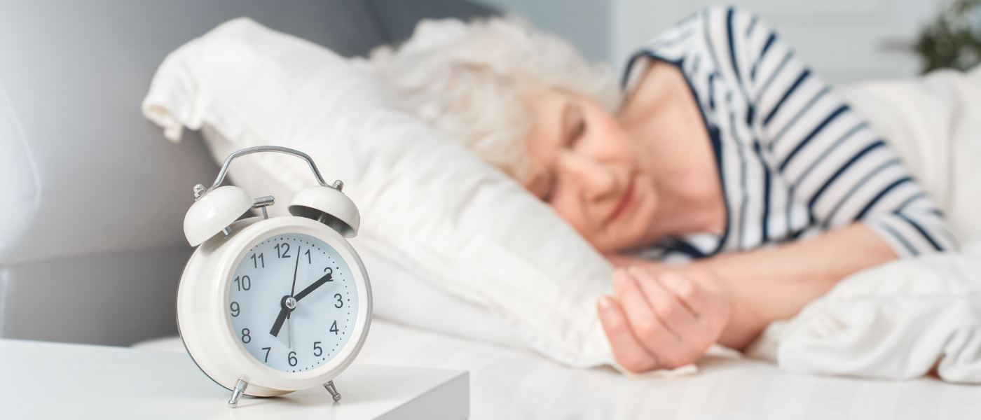 Older adult woman sleeping before her alarm clock rings