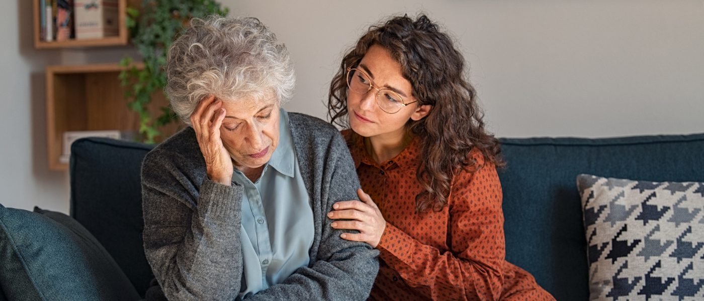 Adult child comforts senior mother